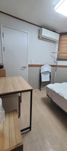a room with a bed and a table and a desk at Sweet House in Seoul