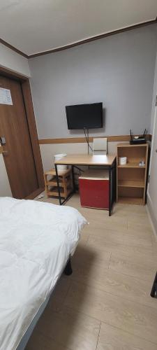 a room with a bed and a desk and a television at Sweet House in Seoul