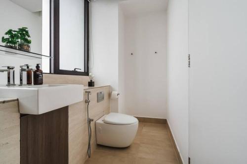 a bathroom with a white toilet and a sink at Lumi Tropicana Muji Concept in Petaling Jaya