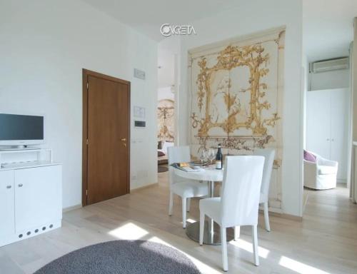 a dining room with a table and white chairs at Hotel Castello di Santa Vittoria in Santa Vittoria dʼAlba