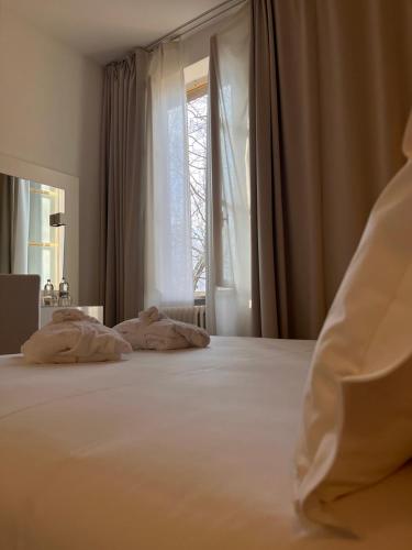 a bedroom with a large white bed with a window at Hotel Castello di Santa Vittoria in Santa Vittoria dʼAlba