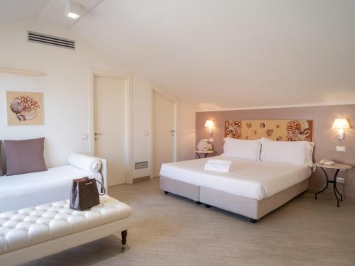 a bedroom with two beds and a couch in it at Hotel San Pietro Palace in Finale Ligure