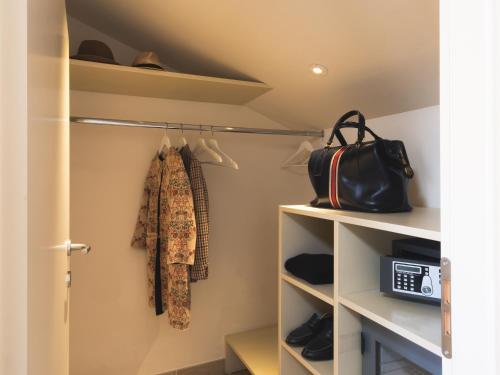 a walk in closet with white shelves and a purse at Hotel San Pietro Palace in Finale Ligure