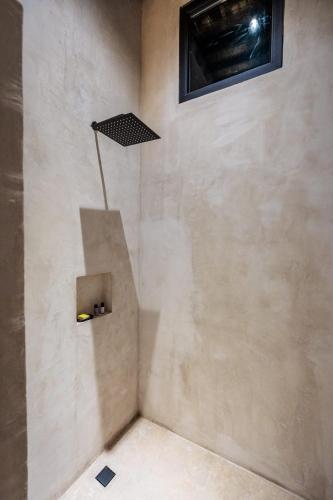 a corner of a bathroom with a wall with a light at Casa 1800 Oaxaca Boutique Hotel City Center based in Oaxaca City