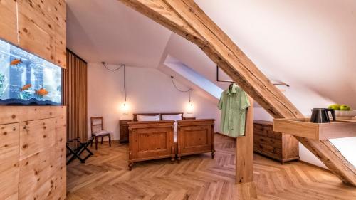 an attic room with wooden floors and wooden beams at Niedermairhof in Brunico