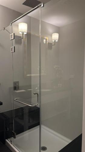 a glass shower stall with two lights on the wall at Boutique Hotel La Casona in Valle de Ángeles