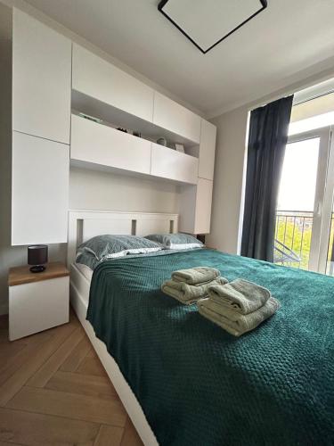 a bedroom with a bed with two towels on it at Witkacy Apartament in Słupsk