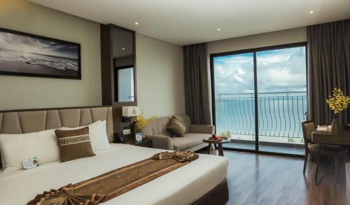 a bedroom with a bed and a view of the ocean at Vipol Mui Ne Hotel & Spa in Mui Ne