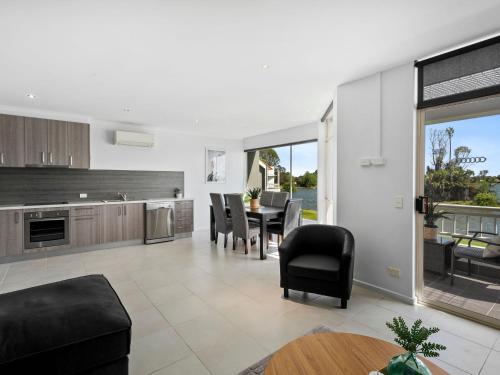 a kitchen and living room with a table and chairs at Yarrawonga Lakeside Apartment 50 in Mulwala