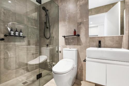 a bathroom with a toilet and a sink and a shower at Stylish and Spacious 2BR w Study, Wi-Fi and Car Park in Carnegie