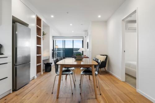 a kitchen and dining room with a table and chairs at Stylish and Spacious 2BR w Study, Wi-Fi and Car Park in Carnegie