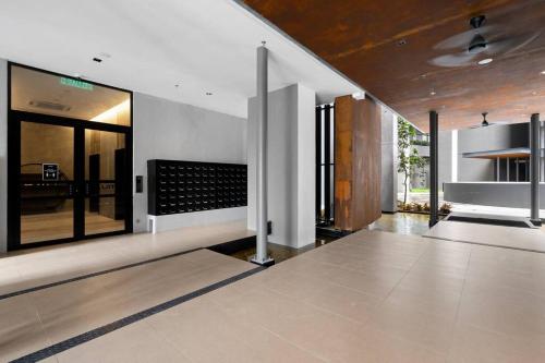 a living room with a large window and a kitchen at Lumi Tropicana Muji in Petaling Jaya