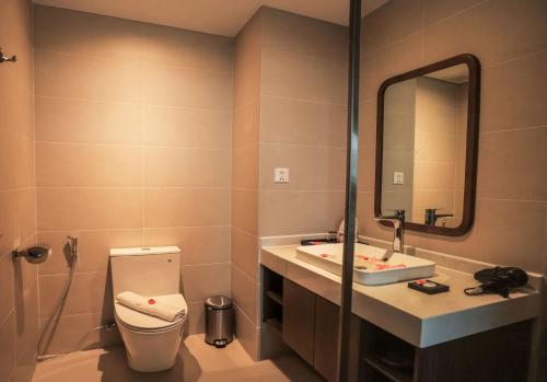 a bathroom with a toilet and a sink and a mirror at Vipol Mui Ne Hotel & Spa in Mui Ne