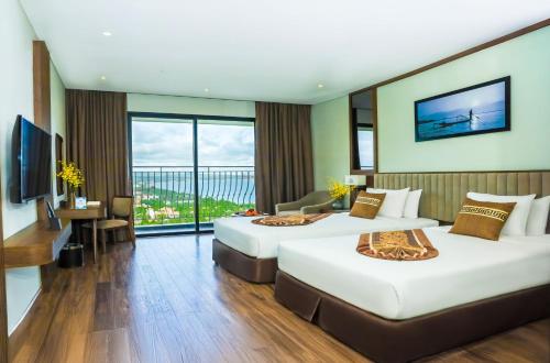 a hotel room with two beds and a television at Vipol Mui Ne Hotel & Spa in Mui Ne