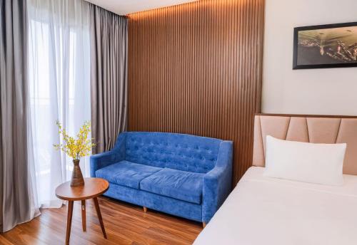 a room with a blue chair and a bed at Vipol Mui Ne Hotel & Spa in Mui Ne