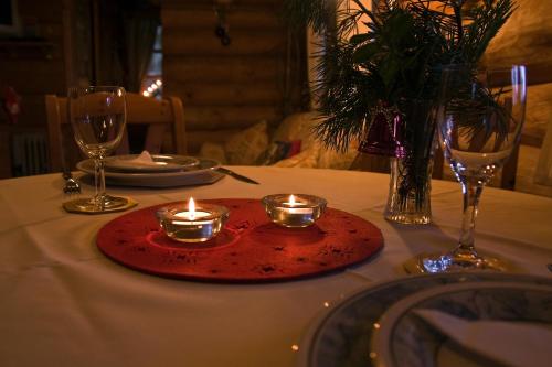 a table with a red plate with candles on it at Forest Edge Lodge in Rīga