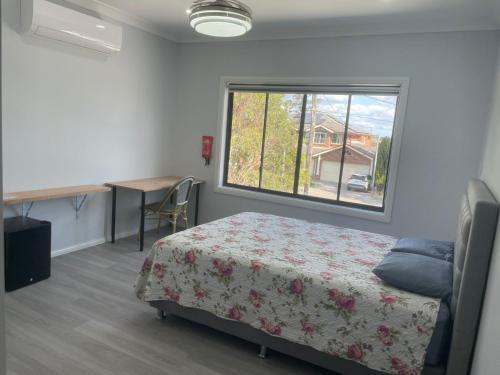 a bedroom with a bed and a window and a desk at Quiet Spacious Family House 11 Bedrooms in Colyton