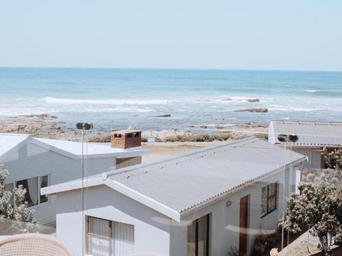 a white house with a view of the ocean at KnusRus in Jongensfontein