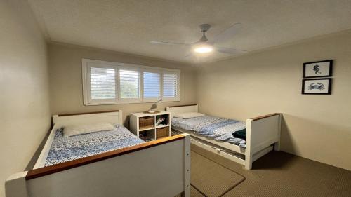 a bedroom with two beds and a window at Sandy Cove Unit 6 in Caloundra