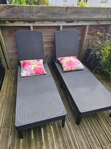 two chairs with pillows sitting on a deck at Cocon in Plérin