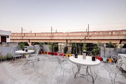 ニューデリーにあるHotel The Rasa Near Welcome Metro Stationのパティオ(テーブル2台、椅子付)