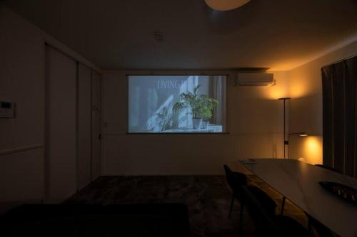 a room with a screen with a potted plant on it at AMP FLAT Hontosu in Tashiro