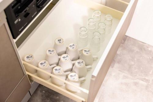 a drawer filled with white milk bottles in a kitchen at AMP FLAT Hontosu in Tashiro