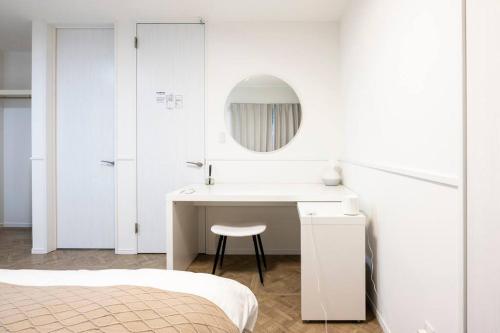 a white bathroom with a sink and a mirror at AMP FLAT Hontosu in Tashiro