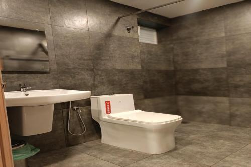 a bathroom with a white toilet and a sink at Green Tea Hotels in Devikolam