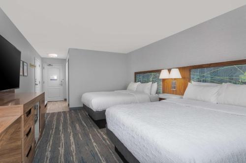 a hotel room with two beds and a flat screen tv at Hampton Inn and Suites - Lincoln Northeast in Lincoln