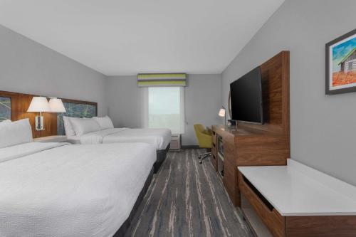 a hotel room with two beds and a flat screen tv at Hampton Inn and Suites - Lincoln Northeast in Lincoln