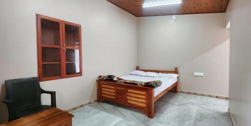 a small bedroom with a bed and a window at Heath Cote in Ooty