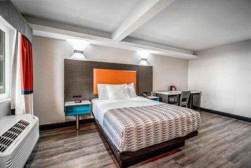 a hotel room with a bed and a desk at Rodeway Inn South Gate - Los Angeles South in South Gate
