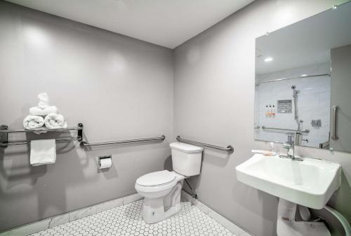 a bathroom with a toilet and a sink at Rodeway Inn South Gate - Los Angeles South in South Gate