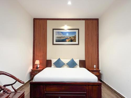 a bedroom with a bed with a picture on the wall at Brenta Phu Quoc Hotel in Phu Quoc