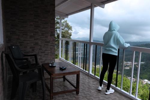 a person standing on a balcony looking out at the city at Heath Cote in Ooty
