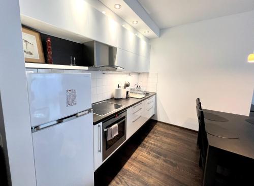 una cucina con un frigorifero bianco e un tavolo di Zygio Apartamentai a Vilnius