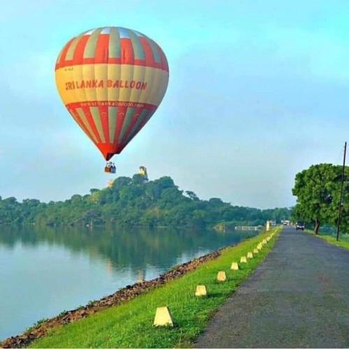 a hot air balloon flying over a river at Sigiri Rangana Guesthouse in Sigiriya