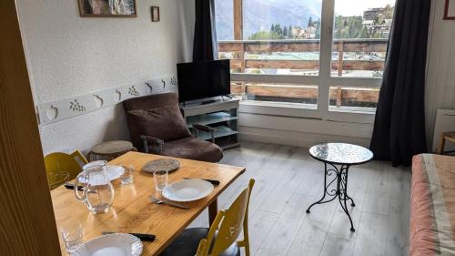 - un salon avec une table, un canapé et une fenêtre dans l'établissement Résidence Rond-point-pistes Ii - Maxi studio 5 pers.au rond point des pistes 65B avec WIFI MAE-7074, à Orcières