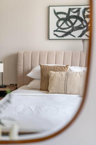a mirror reflection of a bed with pillows on it at GuestReady - Elegant 1BR l Premium Amenities in Dubai