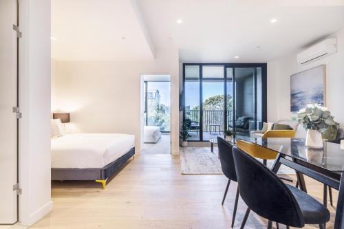 墨尔本Alluring Oasis in the Heart of South Melbourne的一间卧室，配有一张床和一张桌子和椅子
