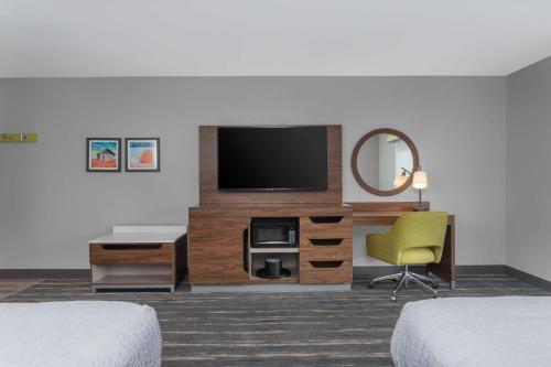 a hotel room with a television and a desk and a chair at Hampton Inn and Suites - Lincoln Northeast in Lincoln