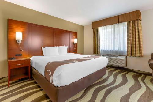 a hotel room with a large bed and a window at Quality Inn & Suites Stoughton - Madison South in Stoughton