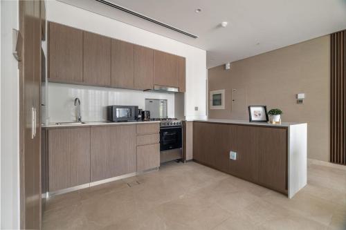 a large kitchen with wooden cabinets and appliances at GuestReady - Elegant 1BR l Premium Amenities in Dubai