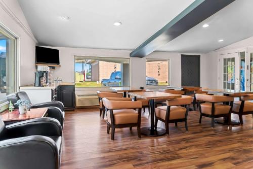 a restaurant with tables and chairs and a kitchen at Rodeway Inn & Suites Saginaw I-675 in Saginaw