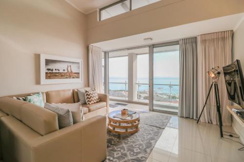 a living room with a couch and a view of the ocean at The Crystal Apartments in Cape Town