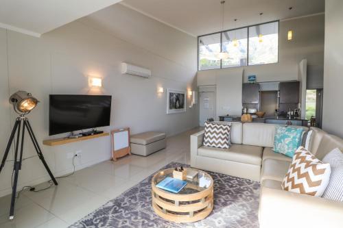 a living room with a couch and a tv at The Crystal Apartments in Cape Town