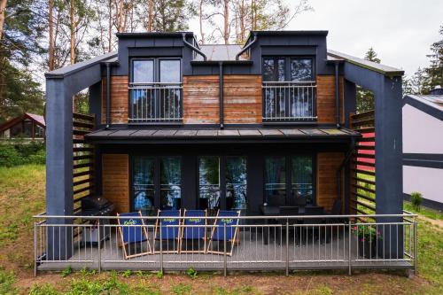 a house with chairs in front of it at Ośrodek Wypoczynkowy Kalwa in Pasym