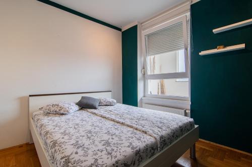 a bedroom with a bed and a green wall at Flexible SelfCheckIns 114 - Zagreb - Bedroom - Loggia in Zagreb