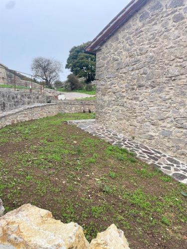 a stone building with a stone wall and grass at Agriturismo Monte Labbro in Zancona